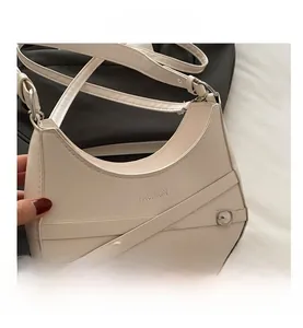Detail view of off-white crescent bag with cross straps and silver buckle finish