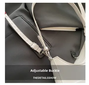 Detail of white leather shoulder bag featuring adjustable silver metal buckle and texture