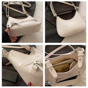 Detail view of white half-moon shoulder bag with adjustable straps and spacious interior