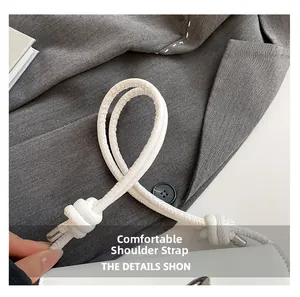Detail of comfortable knotted white leather strap and silver metal buckle on baguette bag