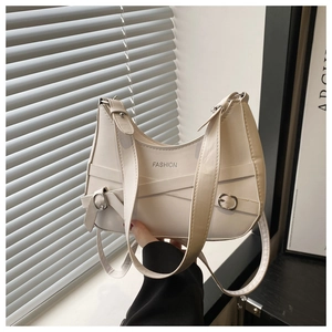 Detail of cream white half-moon hobo bag with crisscross leather straps and silver buckle
