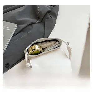 Internal view of a white leather bag showing capacity for lipstick and makeup items
