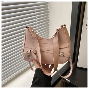 Detail of pink faux leather tote bag featuring a metal bow and FASHION logo