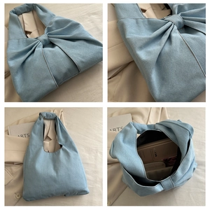 Detail view of large capacity denim tote bag with oversized bow and spacious interior