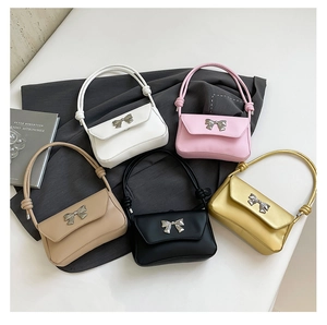 Flat lay of multiple colorful baguette bags with metallic bow details and knotted straps