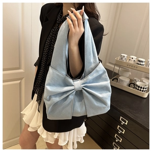 Denim shoulder tote bag featuring a large decorative bow and spacious interior
