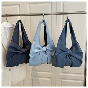 Three denim tote bags with bow design in dark, medium, and light blue shades