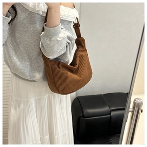 Detailed close-up of brown corduroy hobo bag with adjustable strap and ribbed texture