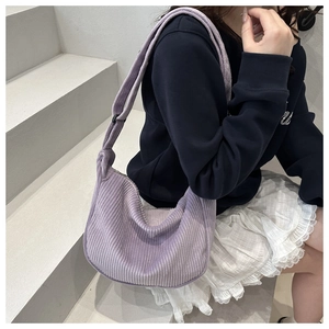 Close-up of a purple corduroy hobo bag on a model, showing texture and casual style