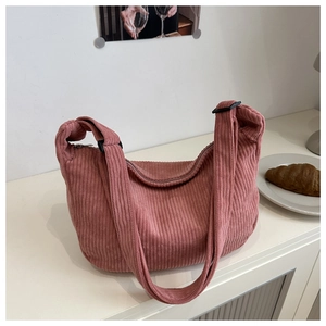 Detail of dusty rose corduroy crescent bag showing fabric texture and adjustable strap