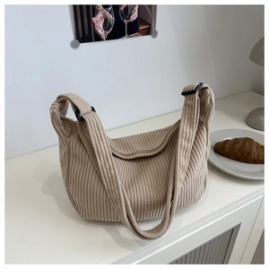Detailed view of beige corduroy crescent bag showing vertical rib texture and strap
