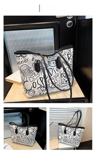 Detailed view of white graffiti tote bag with black cartoon prints and shoulder straps