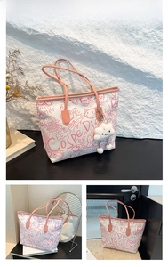 Detail view of white canvas tote bag with pink graffiti patterns and cloud plush charm