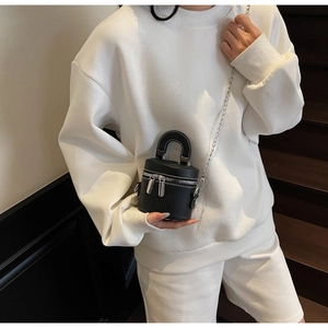 Mini sac cylindrique noir avec chaîne argentée et détails de surpiqûres blanches