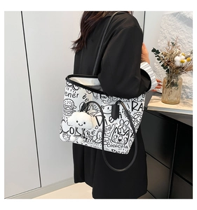 Detail of white graffiti tote bag featuring playful black sketches and a plush cloud charm