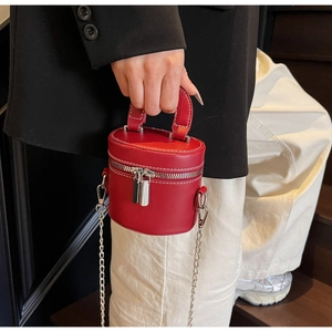 Détail du mini sac seau en cuir rouge avec surpiqûres blanches et chaîne en métal argenté