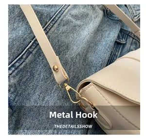 Detailed macro view of high-quality golden metal lobster clasp on beige leather handbag