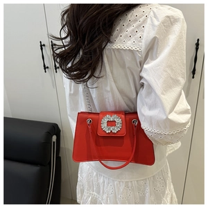 Detail of red crossbody bag with silver chain and iconic square rhinestone buckle