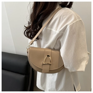 Detail view of khaki faux leather saddle bag with golden geometric metal buckle
