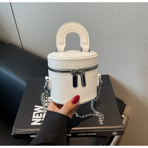 Detailansicht der weißen Mini-Beuteltasche mit silbernen Zippern und Metallkettenriemen