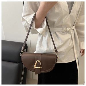 Gros plan du sac besace marron avec boucle triangulaire dorée et similicuir lisse poli