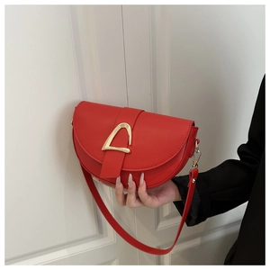 Vue détaillée d'un sac selle demi-lune rouge avec une boucle géométrique en métal doré