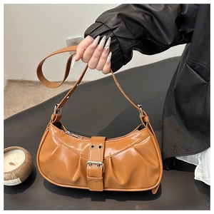 Detail of brown pleated crescent bag with leather strap and silver buckle detail