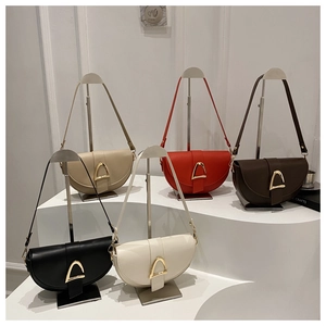 Detailed view of leather saddle shoulder bags in five colors on metal display stands