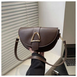 Détail du sac selle vintage en cuir marron foncé avec boucle dorée en forme de D