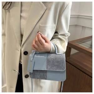 Détail du sac bandoulière en patchwork bleu et gris avec texture premium sur modèle