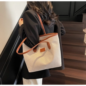 Cream canvas tote bag with brown leather trim shown on model for daily commuting