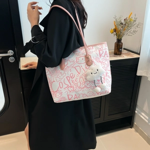 Graffiti canvas tote bag with pink straps and cloud pendant shown in a lifestyle setting