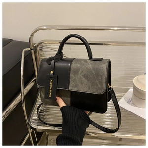 Dettaglio di una piccola borsa quadrata francese con cuciture a contrasto e manico