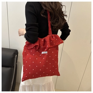 Dettaglio della borsa floreale rossa con volant e etichetta magic pocket a tracolla