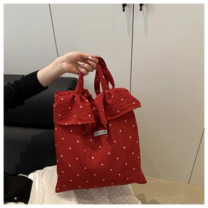 Dettaglio della borsa tote in mesh rossa a fiori con bordi a balze e logo Magicpocket