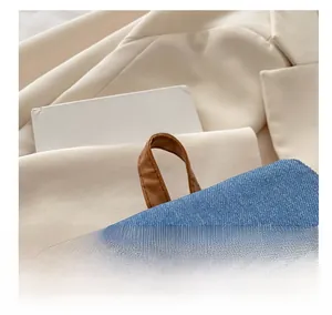 Close-up of comfortable brown leather handle on a blue denim backpack for women