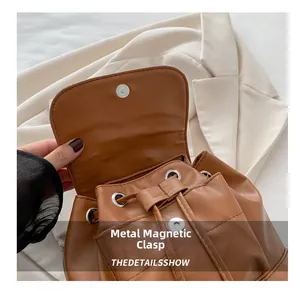 Detail of the magnetic snap closure and drawstring on the vintage brown leather backpack