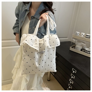 Detail of floral mesh tote bag with ruffles and brand tag on a model side-carry