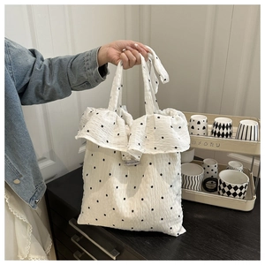 Detail of white ruffle mesh tote bag with black floral pattern and Magic pocket label