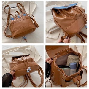 Detail view of brown PU leather backpack with denim patchwork and beaded side charms
