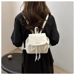 Close-up of white leather mini backpack with FASHION logo and drawstring details