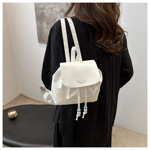 Back view of a mini white PU leather backpack featuring a drawstring and bead detail