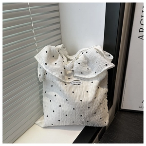 Detail view of the floral mesh texture and Magic pocket label on the white tote bag