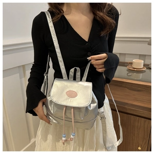 Detail of silver metallic mini backpack with fashion leather tag and beaded drawstring