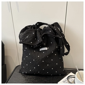 Detail of black mesh tote bag with white flower prints and ruffled bubble texture