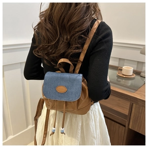 Detail of vintage mini backpack with denim flap and brown leather drawstring closure