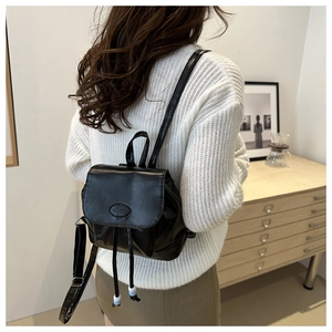 Close-up of black PU leather mini backpack featuring a fashion logo and decorative beads