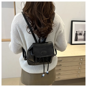 Detailed view of a black mini PU leather backpack with fashion logo and decorative beads