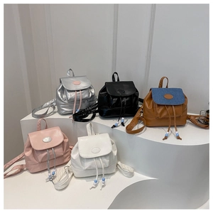 Group display of mini faux leather backpacks in five colors with drawstring and bead details