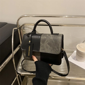 Minimalist geometric patchwork handbag with black leather handle and crossbody strap
